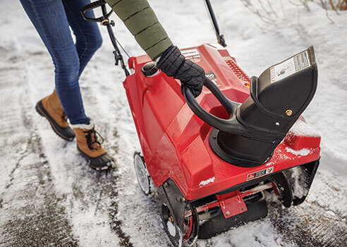 woman adjusting the chute position on a single stage snow blower