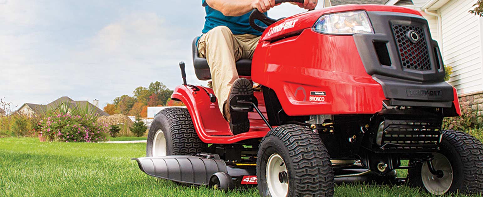 woman mowing her backyard garden