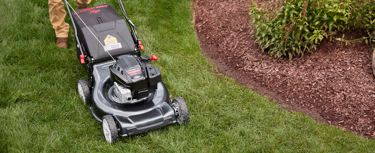 woman pushing walk behind mower